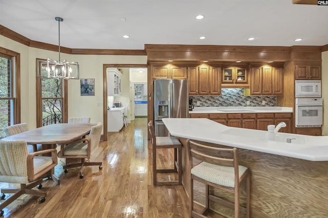 832 Longtown Rd, Blythewood, SC 29016 - kitchen with white appliances, brown cabinets, a chandelier, light countertops, and backsplash