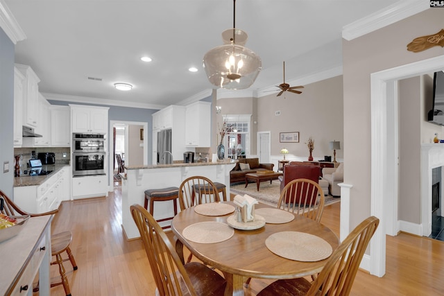 317 Cartgate Cir, Blythewood, SC 29016 - dining space with light wood finished floors, ceiling fan, recessed lighting, ornamental molding, and a fireplace with flush hearth