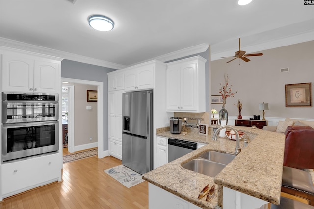 317 Cartgate Cir, Blythewood, SC 29016 - kitchen featuring appliances with stainless steel finishes, a sink, a peninsula, crown molding, and light stone counters
