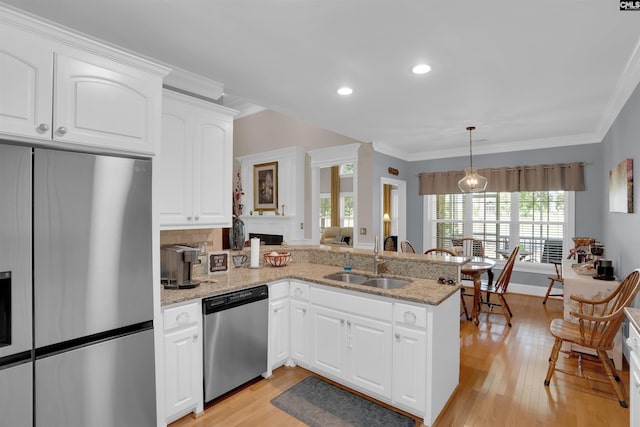 317 Cartgate Cir, Blythewood, SC 29016 - kitchen featuring appliances with stainless steel finishes, a sink, ornamental molding, light wood-type flooring, and light stone counters