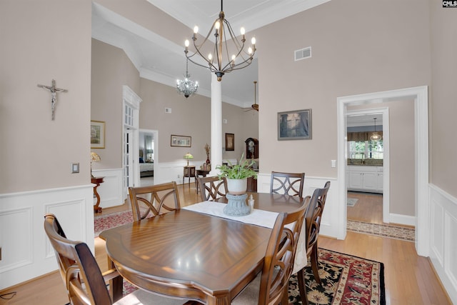 317 Cartgate Cir, Blythewood, SC 29016 - dining room with wainscoting, a high ceiling, a decorative wall, light wood finished floors, and crown molding