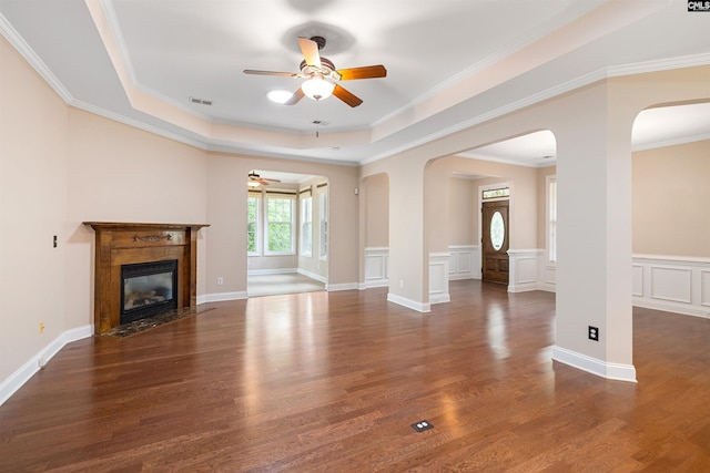 560 Park Place Dr, Elgin, SC 29045 - unfurnished living room featuring a ceiling fan, arched walkways, wood finished floors, a raised ceiling, and ornamental molding
