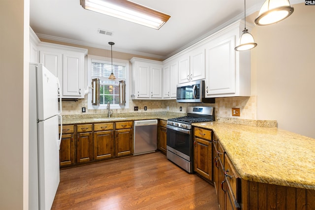 560 Park Place Dr, Elgin, SC 29045 - kitchen with stainless steel appliances, a sink, white cabinets, backsplash, and ornamental molding