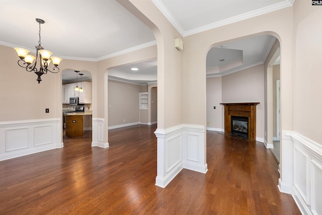 560 Park Place Dr, Elgin, SC 29045 - unfurnished dining area with arched walkways, a fireplace with flush hearth, dark wood-style flooring, crown molding, and a wainscoted wall