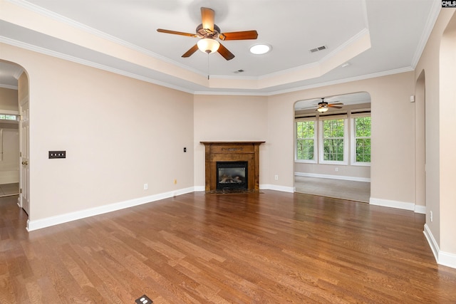 560 Park Place Dr, Elgin, SC 29045 - unfurnished living room with arched walkways, a ceiling fan, wood finished floors, a tray ceiling, and ornamental molding