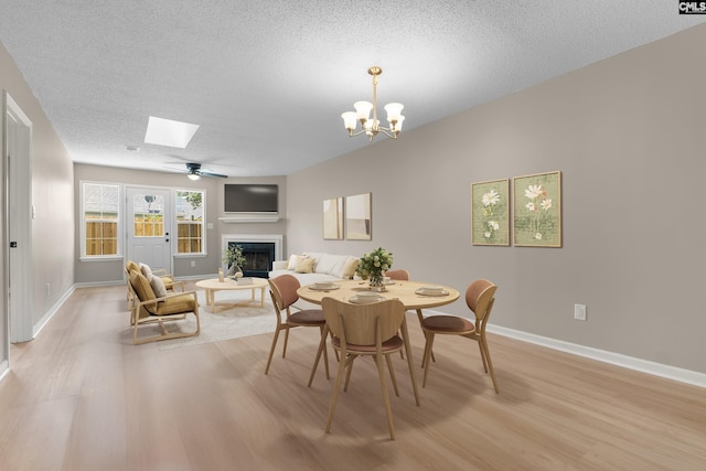 110 Walking Horse Way, Columbia, SC 29223 - dining room with a fireplace, light wood-type flooring, a textured ceiling, baseboards, and a skylight