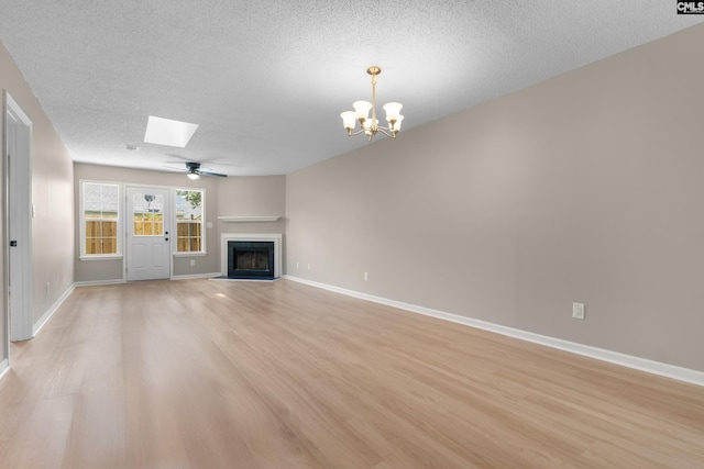 110 Walking Horse Way, Columbia, SC 29223 - unfurnished living room with light wood finished floors, a skylight, a fireplace with flush hearth, a textured ceiling, and a chandelier