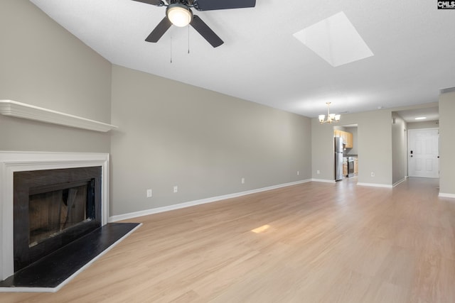 110 Walking Horse Way, Columbia, SC 29223 - unfurnished living room featuring a chandelier, light wood-type flooring, a fireplace with raised hearth, baseboards, and a skylight