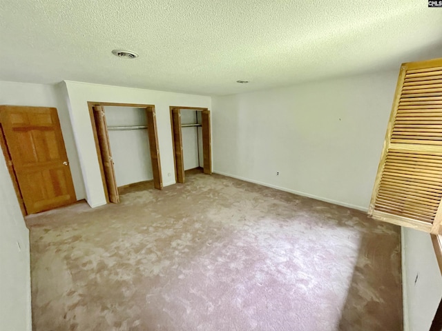 325 Beltline Ave, Batesburg, SC 29006 - unfurnished bedroom with two closets, carpet floors, a textured ceiling, and baseboards
