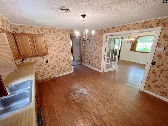 325 Beltline Ave, Batesburg, SC 29006 - unfurnished dining area featuring a chandelier, dark wood-style floors, ornamental molding, wallpapered walls, and a textured ceiling