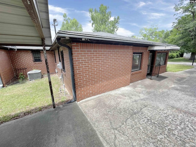 325 Beltline Ave, Batesburg, SC 29006 - view of home's exterior featuring brick siding, central air condition unit, a lawn, and a patio area