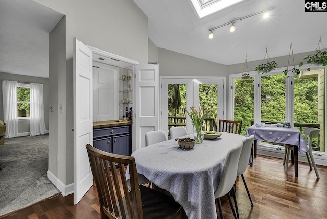 1305 Forest View Rd, Conway, SC 29526 - dining area with vaulted ceiling, a skylight, track lighting, bar area, and baseboards