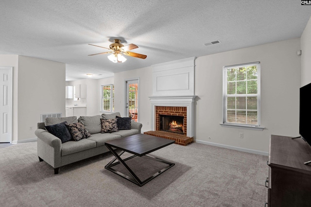 125 Oak Cove Dr, Columbia, SC 29229 - living room featuring a ceiling fan, light carpet, healthy amount of natural light, a fireplace, and a textured ceiling