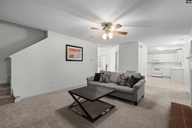 125 Oak Cove Dr, Columbia, SC 29229 - living room featuring light colored carpet, stairs, a ceiling fan, a textured ceiling, and baseboards
