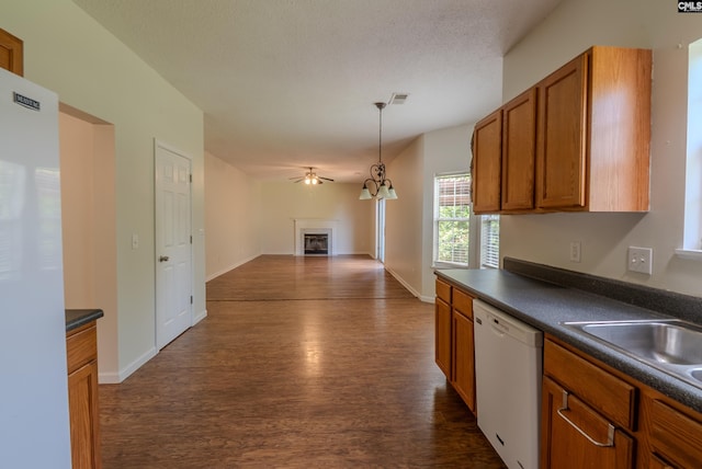 105 Songbird Ct, Chapin, SC 29036 - kitchen featuring white appliances, dark countertops, dark wood-type flooring, brown cabinetry, and open floor plan