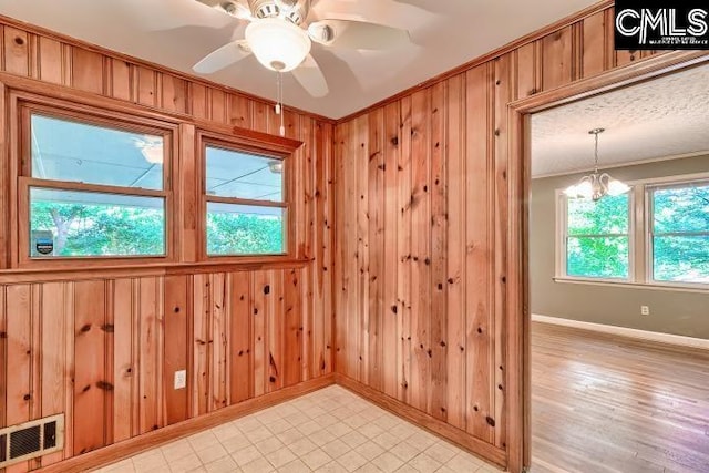 127 Lake Elizabeth Dr, Columbia, SC 29203 - unfurnished room featuring ornamental molding, baseboards, wooden walls, a ceiling fan, and a chandelier