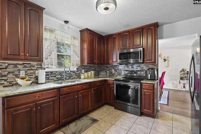 300 Green Rose, Columbia, SC 29229 - kitchen featuring appliances with stainless steel finishes, a sink, light stone countertops, a textured ceiling, and backsplash