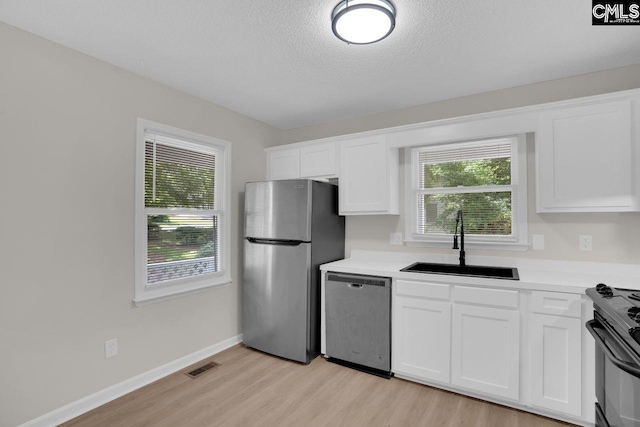 204 Sandcreek Dr, Winnsboro, SC 29180 - kitchen featuring appliances with stainless steel finishes, a sink, light wood-style floors, white cabinets, and light countertops