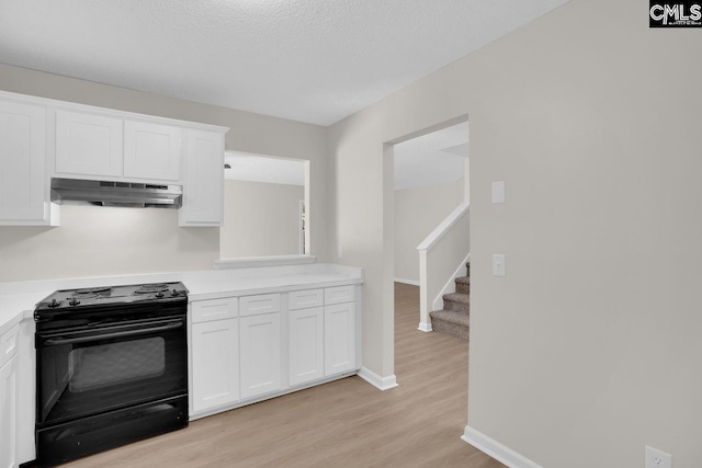 204 Sandcreek Dr, Winnsboro, SC 29180 - kitchen with exhaust hood, black range oven, light countertops, light wood-style flooring, and white cabinets