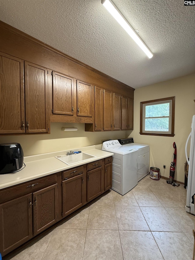 3270 Winchester Ln, Orangeburg, SC 29118 - laundry area featuring a textured ceiling, washing machine and clothes dryer, cabinet space, and light tile patterned floors