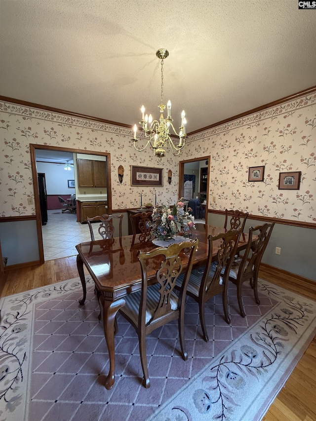 3270 Winchester Ln, Orangeburg, SC 29118 - dining space featuring crown molding, wood finished floors, wallpapered walls, wainscoting, and a chandelier
