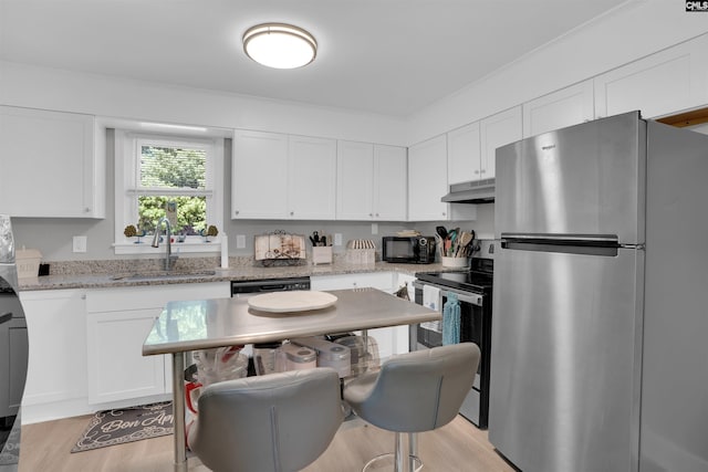 1321 C Ave, West Columbia, SC 29169 - kitchen with stainless steel appliances, under cabinet range hood, a sink, and white cabinets