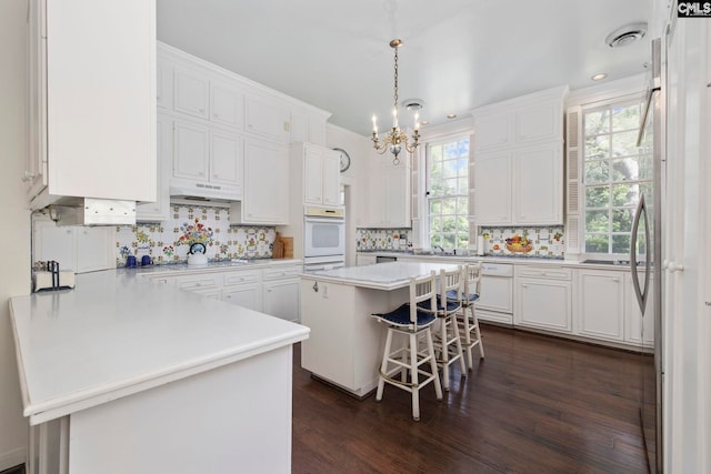 1100 W Carolina Ave, Hartsville, SC 29550 - kitchen with a chandelier, a peninsula, white cabinetry, backsplash, and recessed lighting