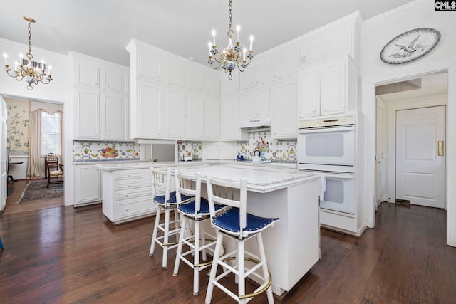 1100 W Carolina Ave, Hartsville, SC 29550 - kitchen featuring a chandelier, double oven, a center island, dark wood finished floors, and ornamental molding