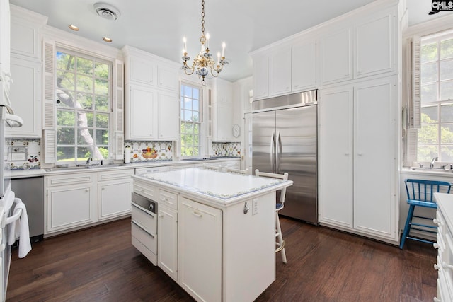 1100 W Carolina Ave, Hartsville, SC 29550 - kitchen with stainless steel appliances, dark wood-style floors, white cabinetry, a chandelier, and recessed lighting