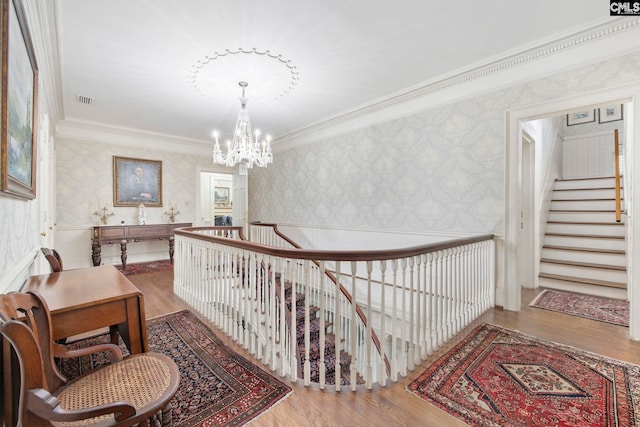 1100 W Carolina Ave, Hartsville, SC 29550 - hallway featuring wallpapered walls, crown molding, wood finished floors, a chandelier, and stairs