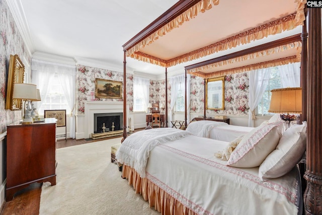 1100 W Carolina Ave, Hartsville, SC 29550 - bedroom featuring wallpapered walls, multiple windows, crown molding, a fireplace, and wood finished floors