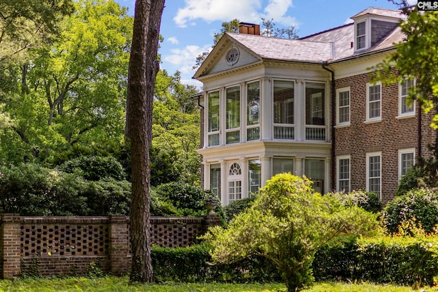 1100 W Carolina Ave, Hartsville, SC 29550 - view of side of home featuring a chimney, a sunroom, and brick siding