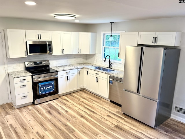104 Farmington Rd, Columbia, SC 29223 - kitchen with stainless steel appliances, a sink, white cabinetry, light stone counters, and recessed lighting
