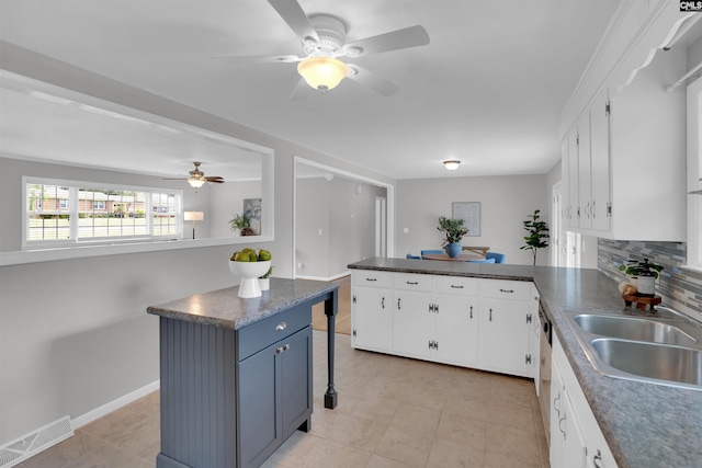 344 Rawls Dr, Leesville, SC 29070 - kitchen featuring a ceiling fan, a peninsula, white cabinetry, decorative backsplash, and dark countertops