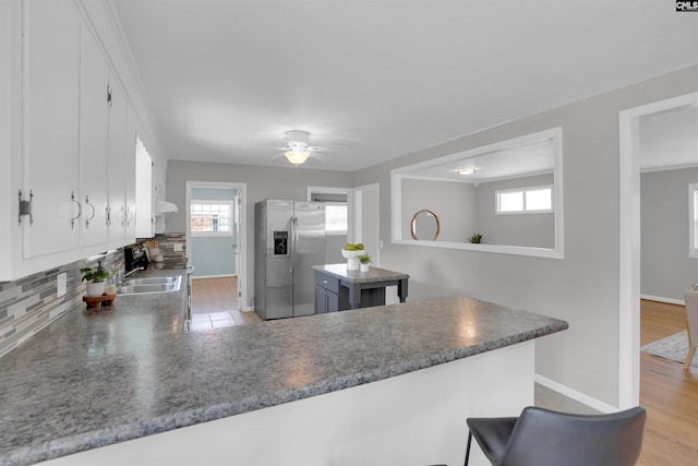 344 Rawls Dr, Leesville, SC 29070 - kitchen with stainless steel fridge, backsplash, white cabinetry, a peninsula, and ceiling fan