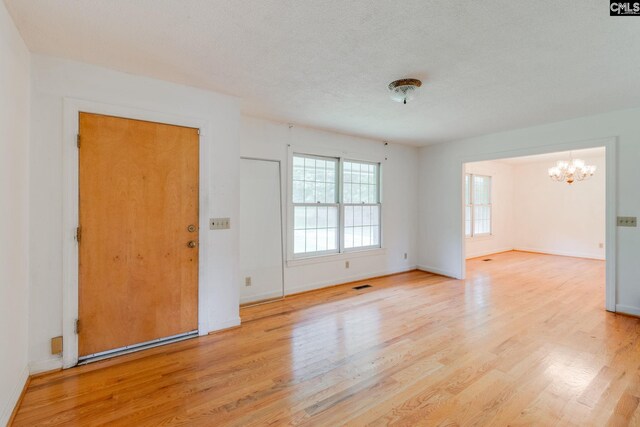 2117 Togetherness Way, Mcbee, SC 29101 - entryway with a chandelier, wood finished floors, and a textured ceiling