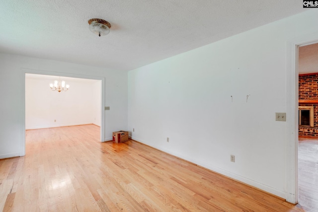 2117 Togetherness Way, Mcbee, SC 29101 - empty room featuring a chandelier, light wood finished floors, and a textured ceiling