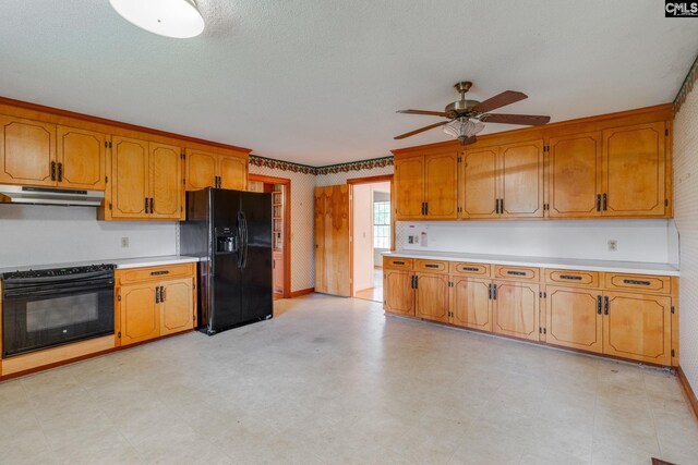 2117 Togetherness Way, Mcbee, SC 29101 - kitchen featuring black appliances, ceiling fan, under cabinet range hood, light countertops, and brown cabinetry