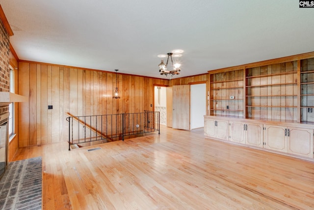 2117 Togetherness Way, Mcbee, SC 29101 - unfurnished living room with a chandelier, wood finished floors, wood walls, and ornamental molding