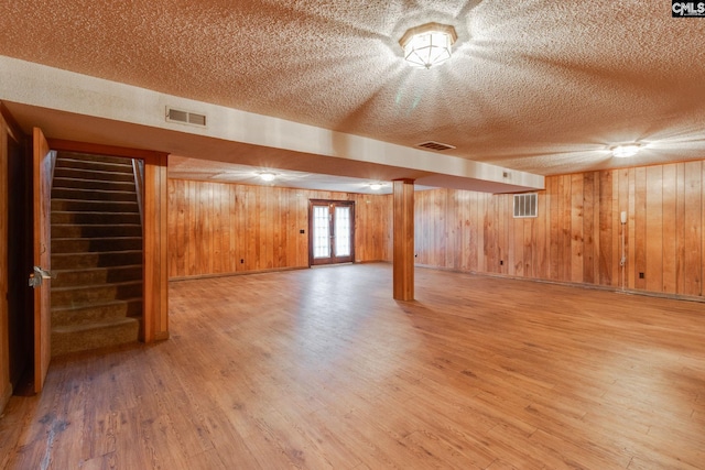 2117 Togetherness Way, Mcbee, SC 29101 - basement featuring stairway, a textured ceiling, light wood-style floors, and wooden walls