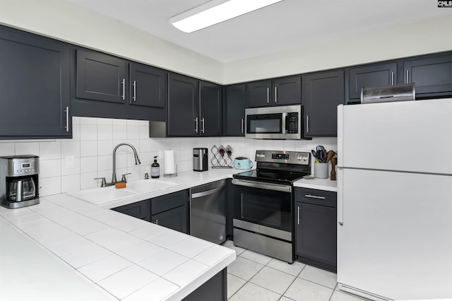 152 Carlyle Cir, Columbia, SC 29206 - kitchen featuring appliances with stainless steel finishes, tasteful backsplash, tile counters, and light tile patterned flooring