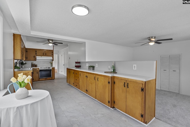 1409 Hazel St, Cayce, SC 29033 - kitchen featuring a ceiling fan, white range, a textured ceiling, under cabinet range hood, and light countertops