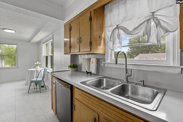1409 Hazel St, Cayce, SC 29033 - kitchen with stainless steel dishwasher, a textured ceiling, brown cabinetry, light countertops, and light tile patterned floors