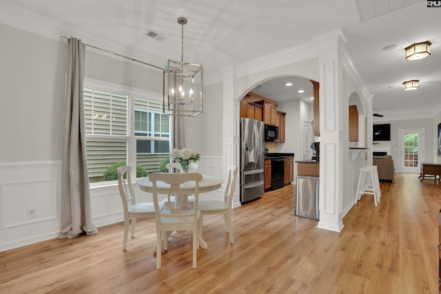 330 Lanyard Ln, Chapin, SC 29036 - dining space featuring arched walkways, a chandelier, light wood-style floors, crown molding, and a decorative wall