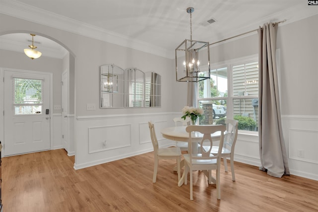 330 Lanyard Ln, Chapin, SC 29036 - dining room featuring arched walkways, a chandelier, a wainscoted wall, crown molding, and light wood-style flooring