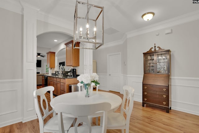 330 Lanyard Ln, Chapin, SC 29036 - dining room with a chandelier, a wainscoted wall, arched walkways, ornamental molding, and light wood-style floors