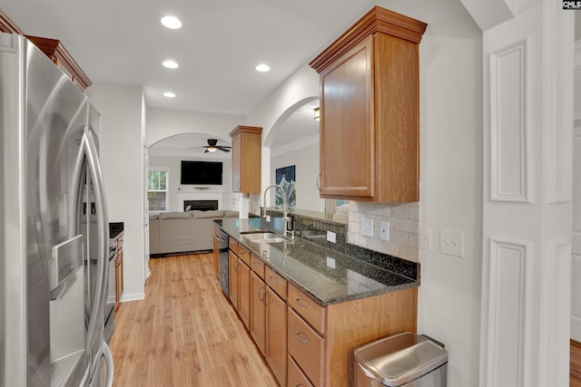 330 Lanyard Ln, Chapin, SC 29036 - kitchen with stainless steel refrigerator with ice dispenser, a fireplace, ceiling fan, arched walkways, and light wood finished floors