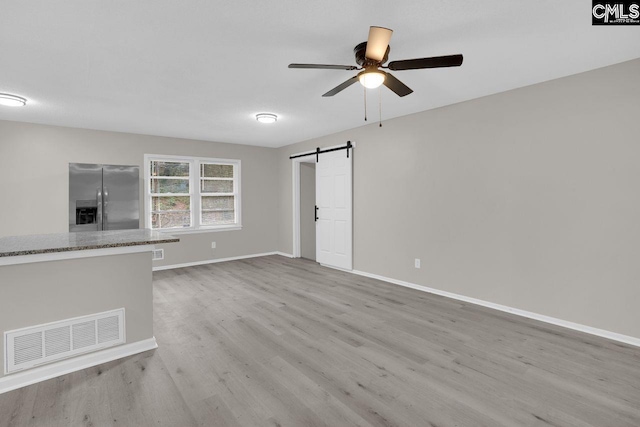 112 Woodcrest Dr, Columbia, SC 29203 - unfurnished living room featuring a barn door, light wood finished floors, and ceiling fan