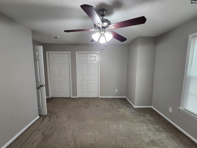 325 Trinity Three Rd, Irmo, SC 29063 - unfurnished bedroom featuring two closets, carpet floors, a textured ceiling, a ceiling fan, and multiple windows