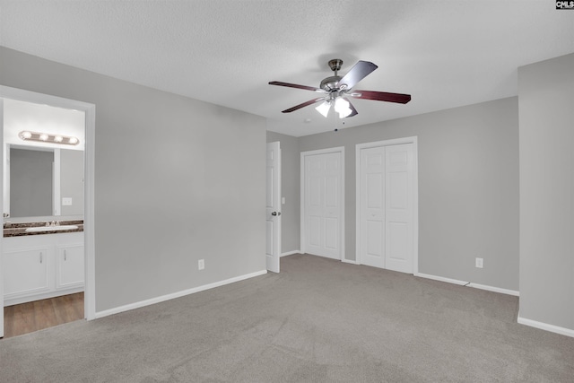 325 Trinity Three Rd, Irmo, SC 29063 - unfurnished bedroom featuring two closets, carpet, ensuite bathroom, ceiling fan, and a textured ceiling